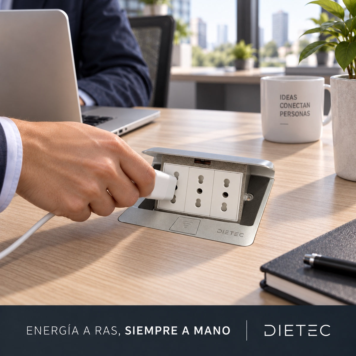 Persona enchufando un cargador en la caja pop up DIETEC empotrada en su escritorio