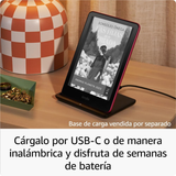 Kindle Paperwhite con soporte de carga USB-C rosa sobre escritorio, rodeado de accesorios decorativos